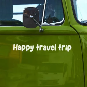 Happy travel trip sticker afgebeeld op een groene volkswagen busje ingezoomd.