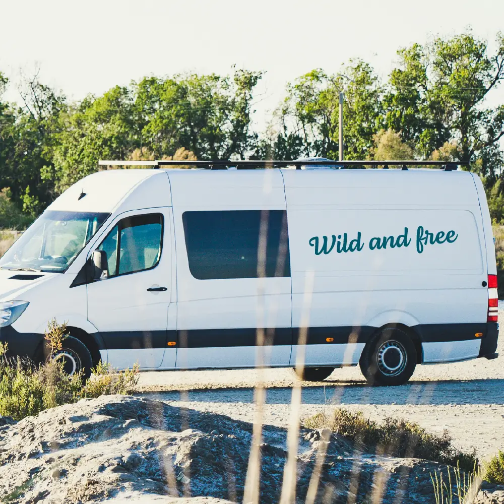 Camperprints Wild and free sticker op een witte vanlife bus