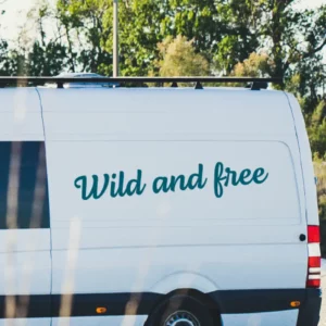 Wild and free sticker op een witte vanlife bus ingezoomd.