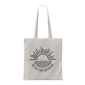 Totebag never stop exploring met zon en zee als tekening hangend op een paal met witte achtergrond.